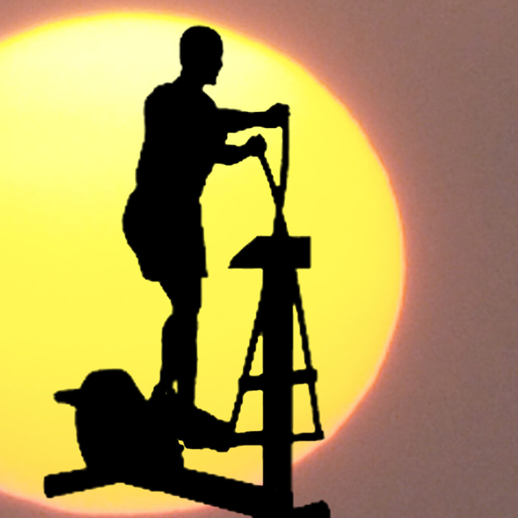 Silhouette of man on exercise machine.